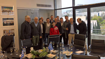 Members of the Greek team of champions in Euro 2004 take a picture with Stavros Niarchos Foundation members in a conference room